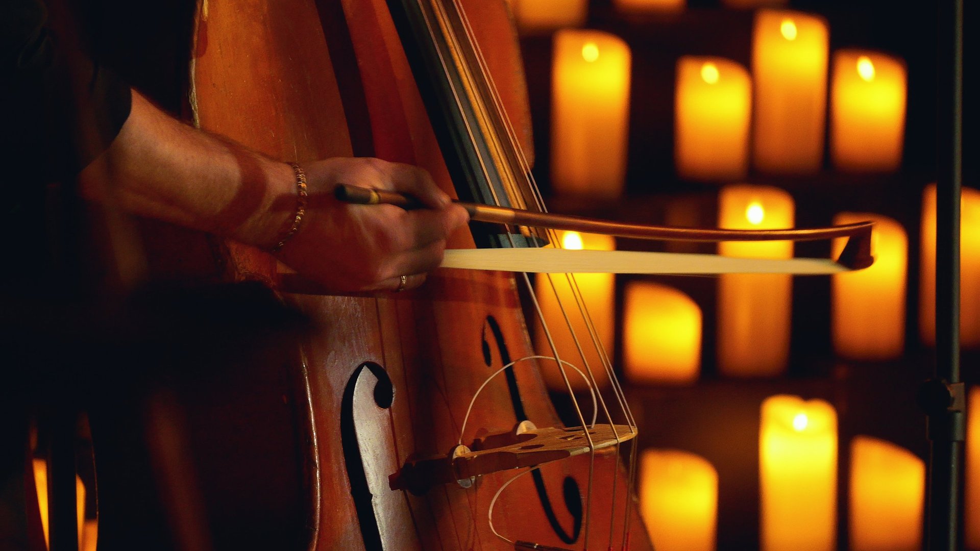Live music atmosphere with double bass on stage surrounded by candles
