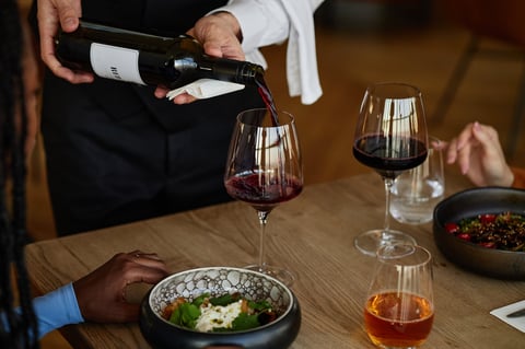 Sommelier pouring wine at elegant dinner