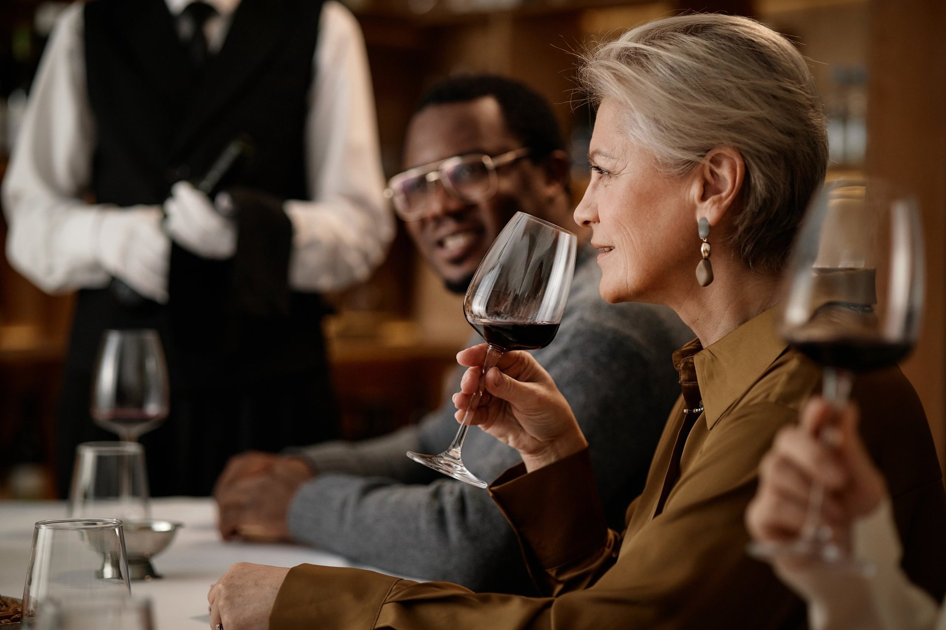 Sophisticated couple enjoying wine tasting with sommelier